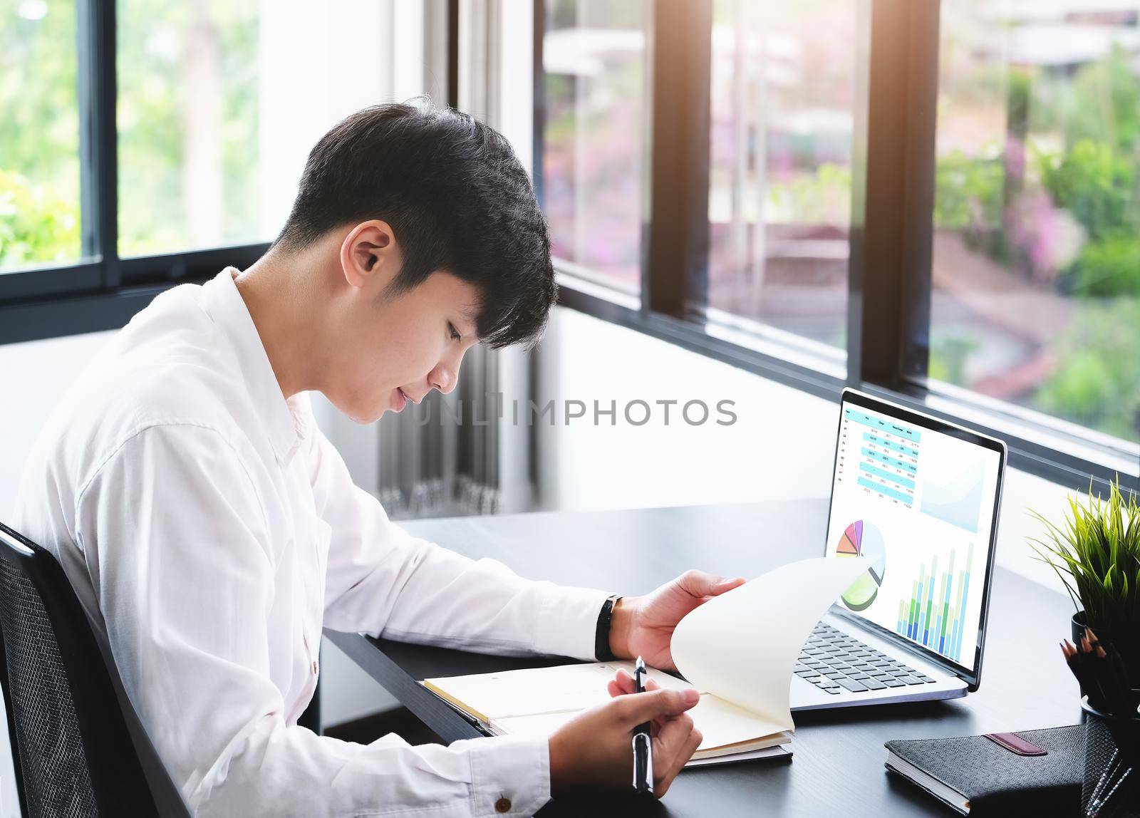 Business man using computer to review balance sheet annual using document to calculating budget. audit and Check integrity before investment concept. by Manastrong