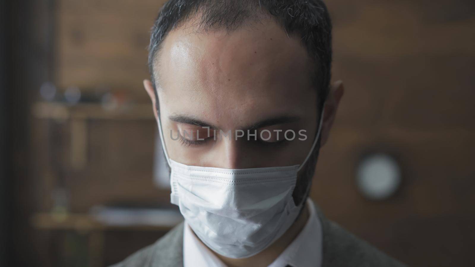 Serious Businessman In Medical Protective Mask Looking Down, Sad Middle Eastern Man Standing Alone In Board Room, Man Forced To Remain On Self-Isolation Due To Coronavirus Outbreak, Quarantine Concept