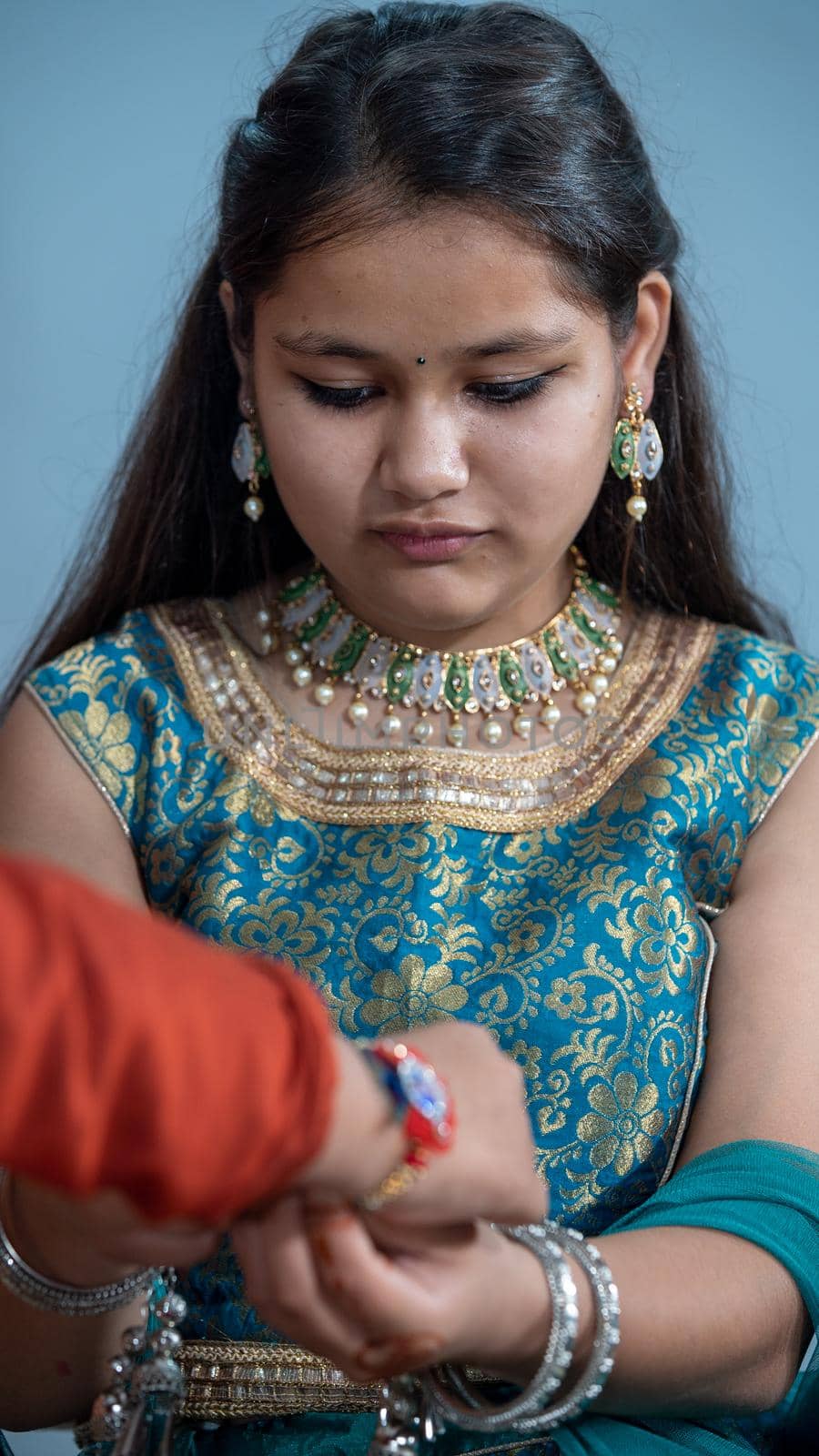 Sister tying the rakhi, Raksha Bandhan to brother's wrist during festival or ceremony - Raksha Bandhan celebrated across India as selfless love or relationship between brother and sister