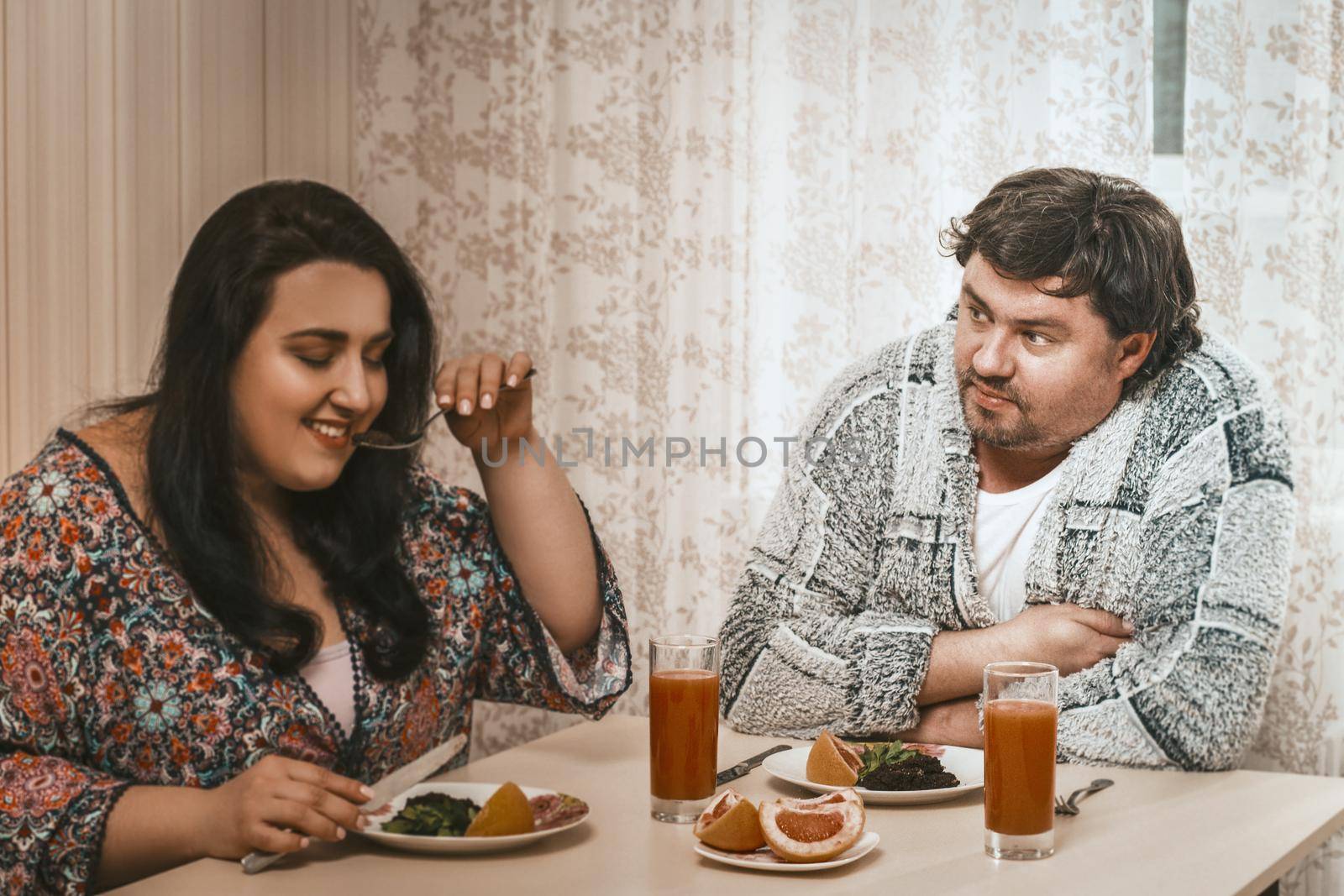 Plus Size Couple About To Eat Healthy Food, Selective Focus On Man In Casual Clothes Looking On Woman Holding Fork In Foreground And Testing Salad From Plate