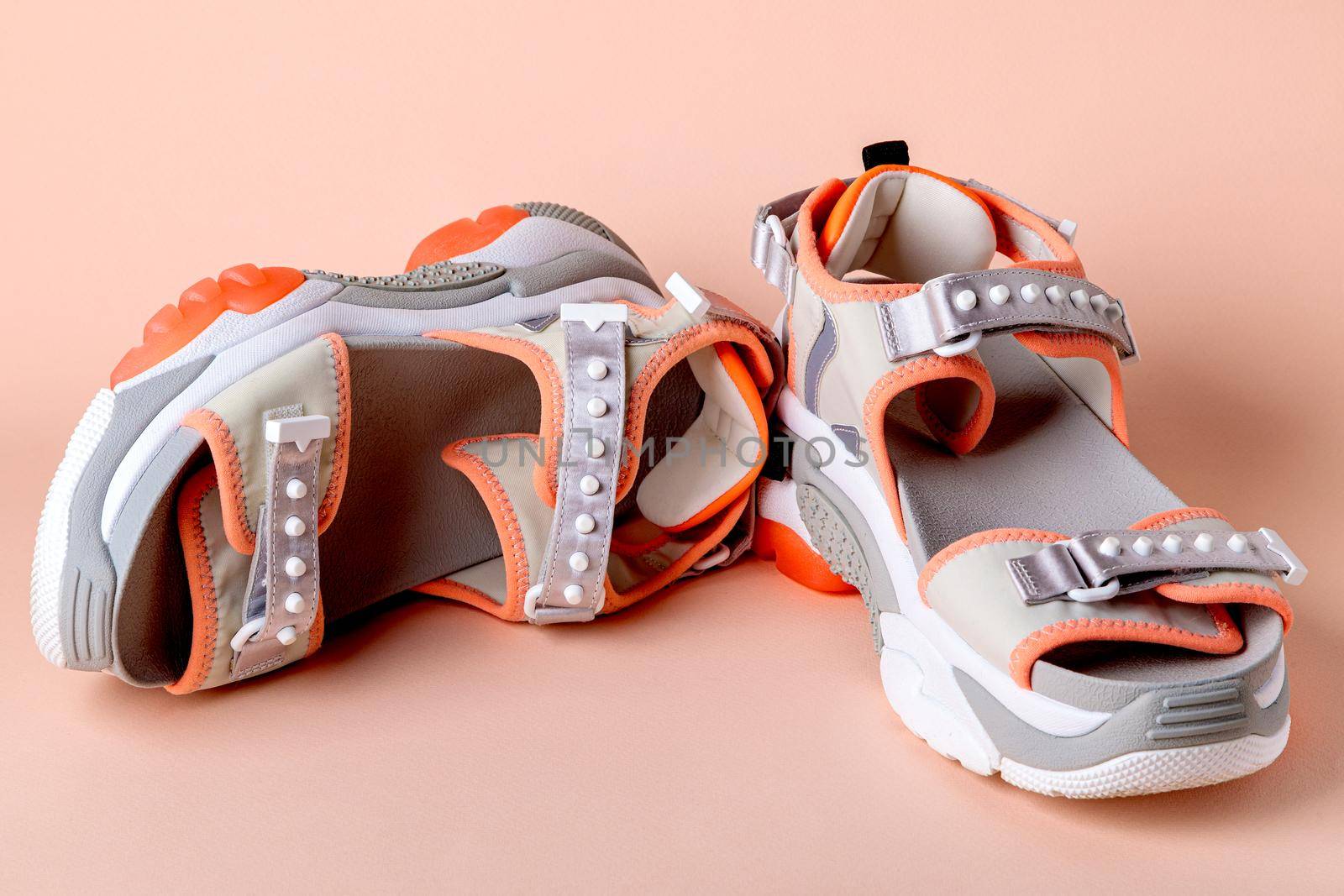 Women's, fashionable, sports sandals with orange accents on a pink background. by Yurich32