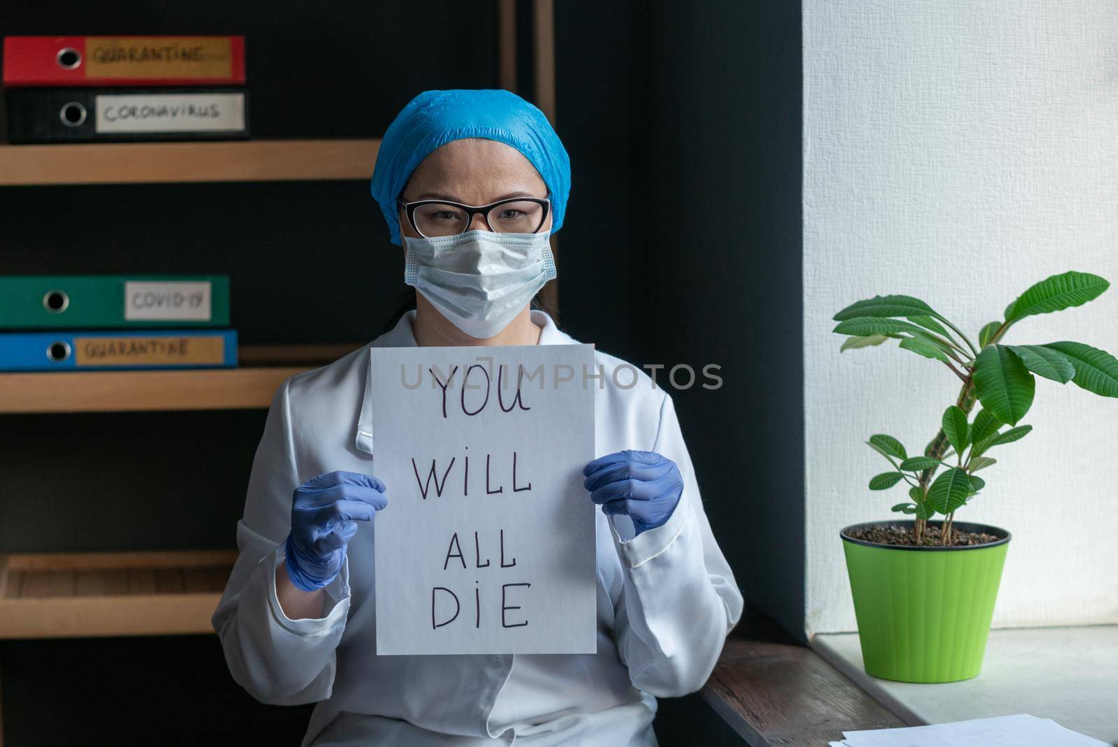 Sad Female Doctor In White Uniform Shows Inscription That Says That Everyone Will Die Due To The Epidemic Of Corona Virus, Woman In Protective Mask Looks Serious And Confident