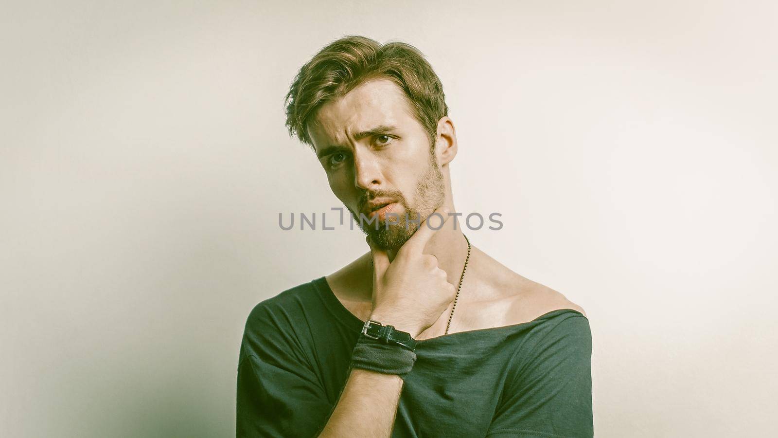 Pensive Caucasian Man Thoughtfully Touching His Chin by LipikStockMedia