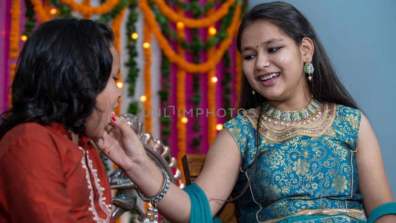 Indian families celebrating Raksha Bandhan festival a festival to celebrate the bond between brother and sister. Rakhi celebration in India. Feeding sweets, applying tikka.