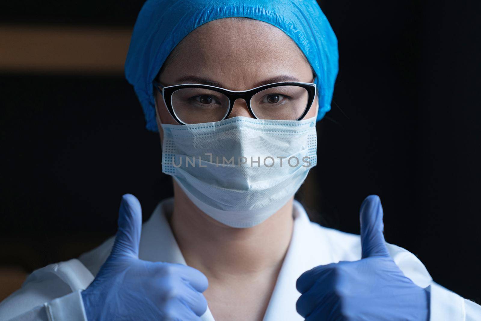 Female Doctor Medical Worker In White Protective Uniform And Surgical Mask Gestures Thumbs Up Showing That Everything Will Be Fine, Medical Laboratory Employee Reports About Good Test Results