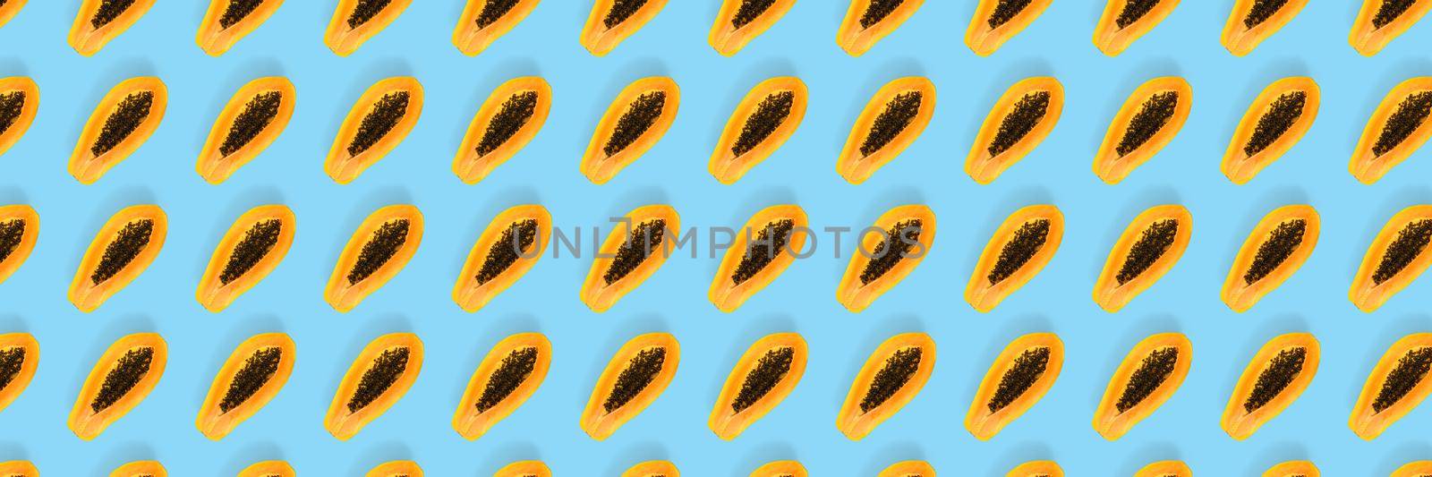 Fresh ripe papaya background on blue backdrop. Modern tropical abstract background. Top view. Creative design, minimal flat lay concept. Trend tropical fruit food background - not seamless pattern