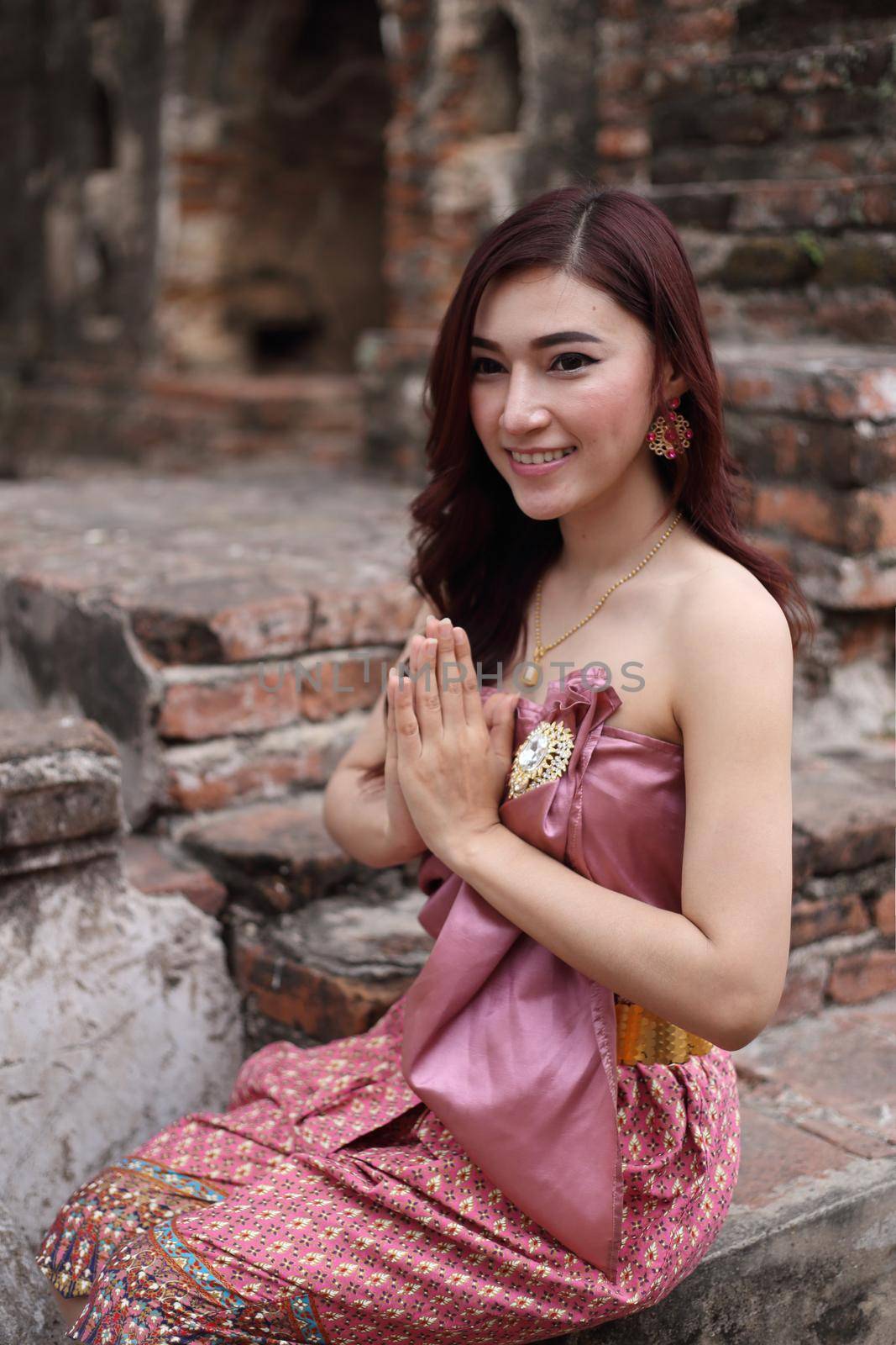 Female pay respect in Thai traditional dress at  historical park