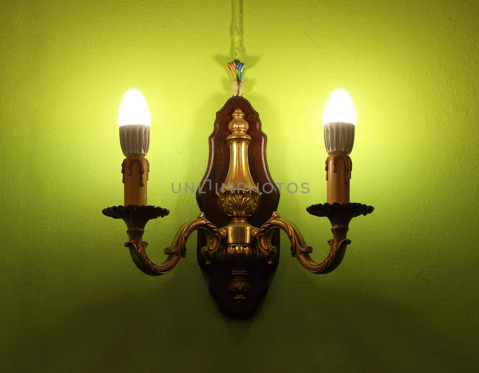 Lighted classic lamp on the green wall