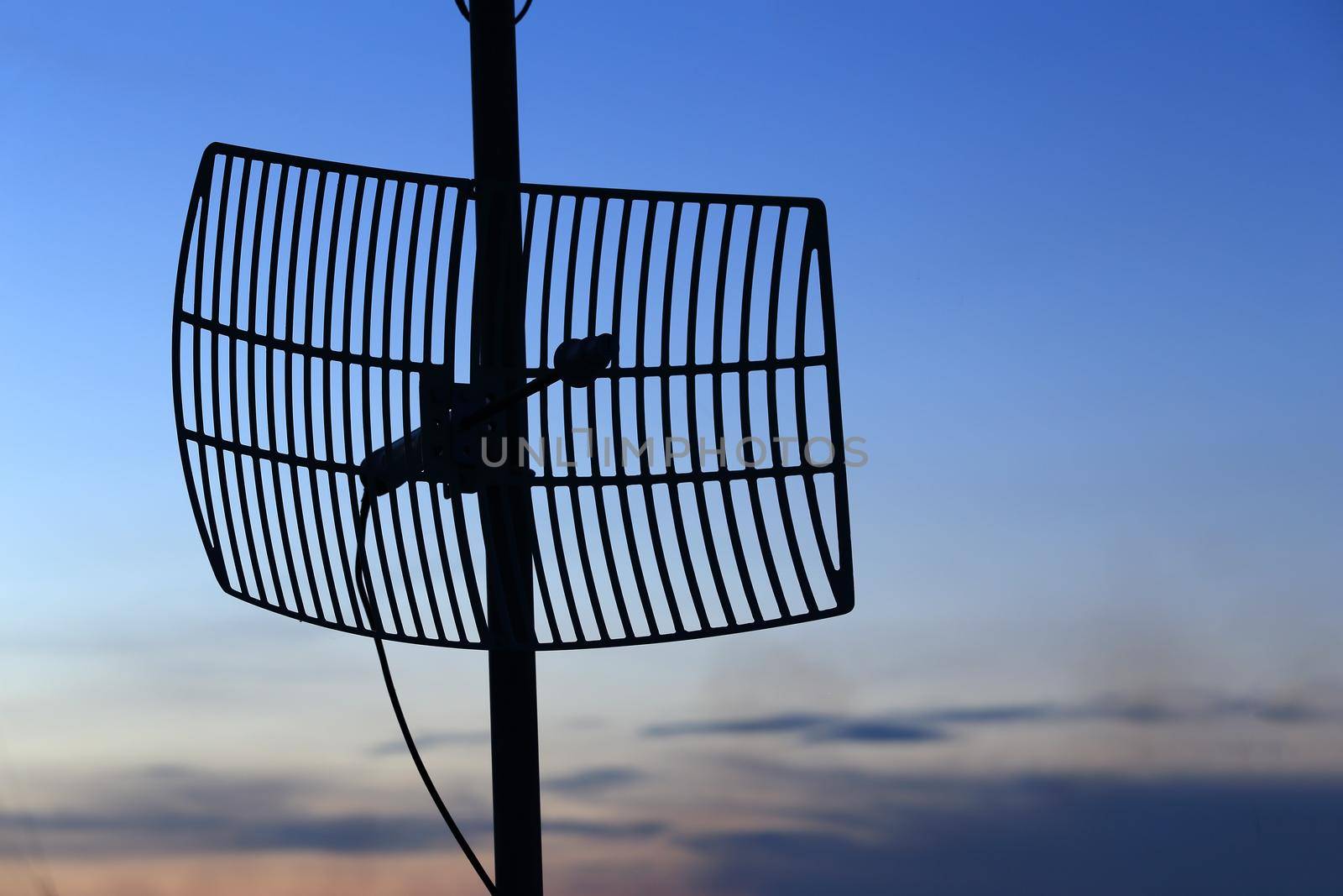 silhouette satellite communication antenna at sunset