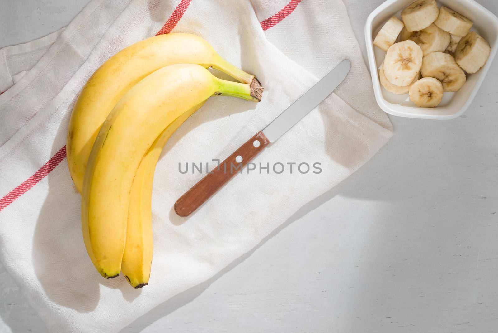 a sliced banana in a bowl on wooden background by makidotvn