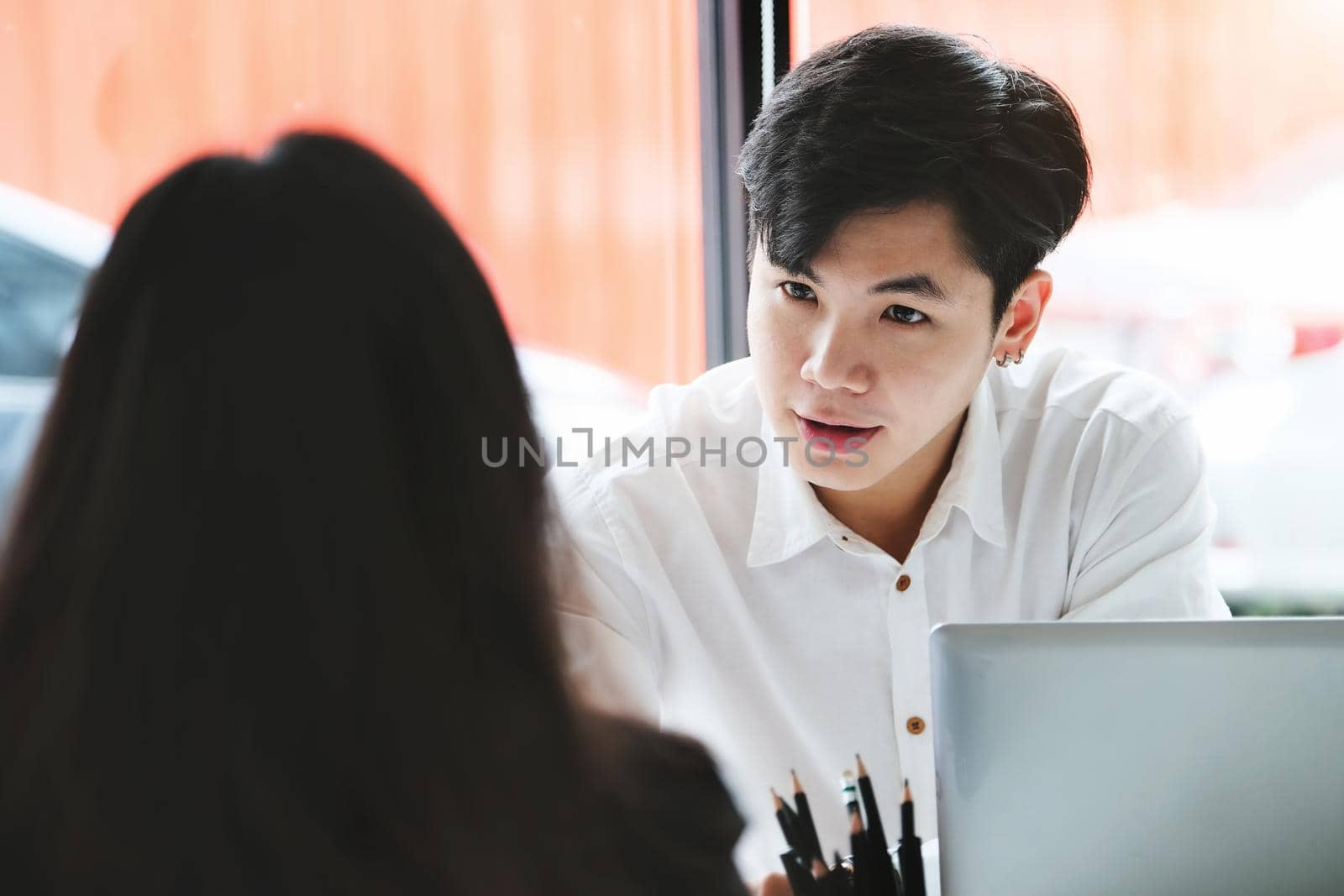 Two young business executives are discussing to change their business concept to increase profits and the strength of their business. by Manastrong