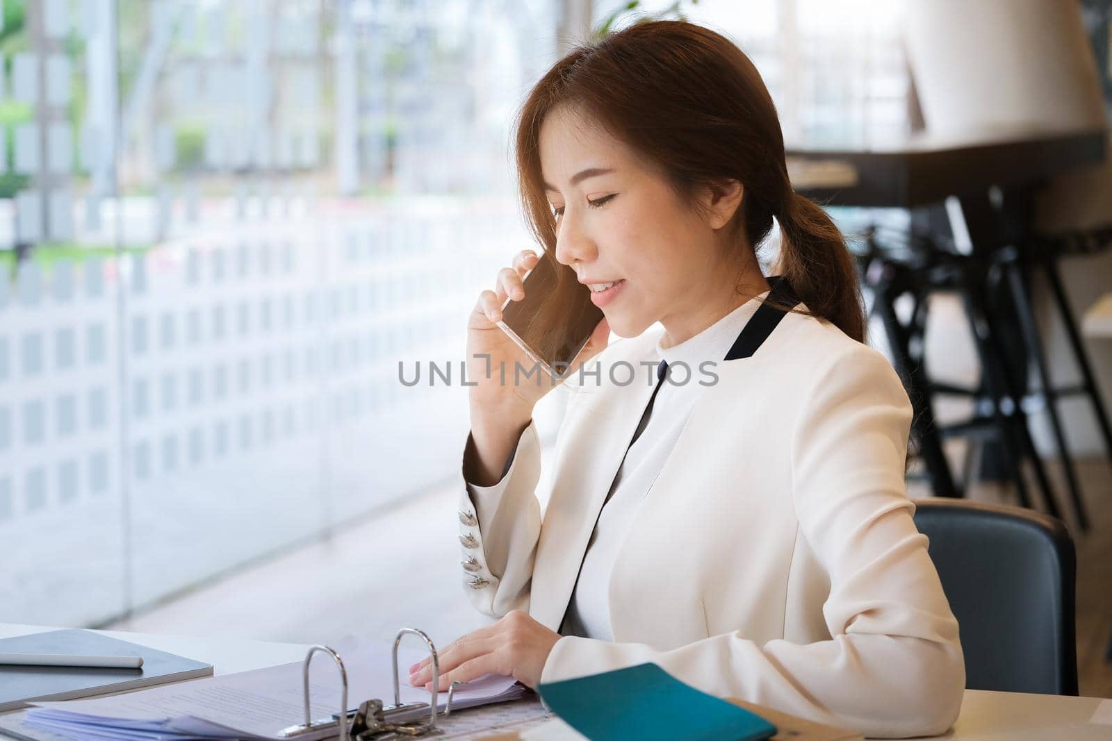 A business woman talking on the phone figured out a profitable way for her company. by Manastrong