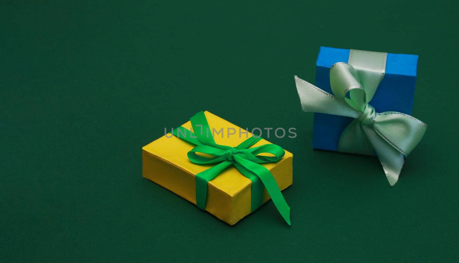 Two Beautiful multicolored gift boxes on green paper background. by gelog67