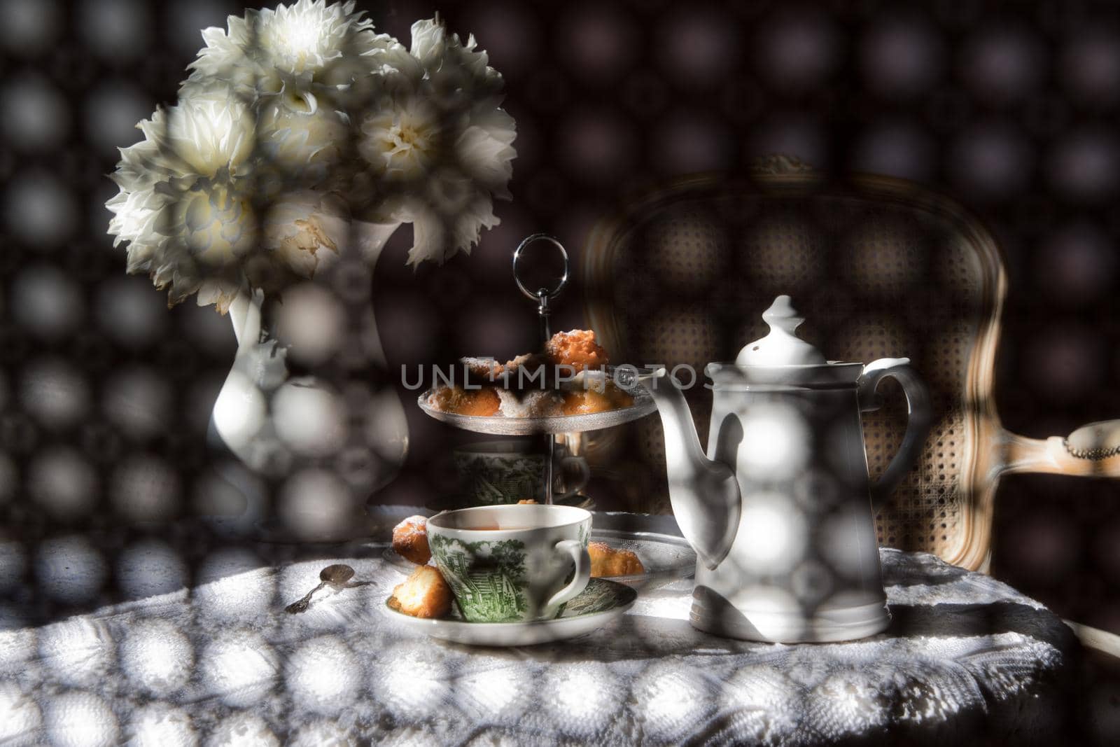 abstract photography over the back of a chair in blur, English style tea break, still life with flowers and donuts in the morning sun, homemade cakes. High quality photo