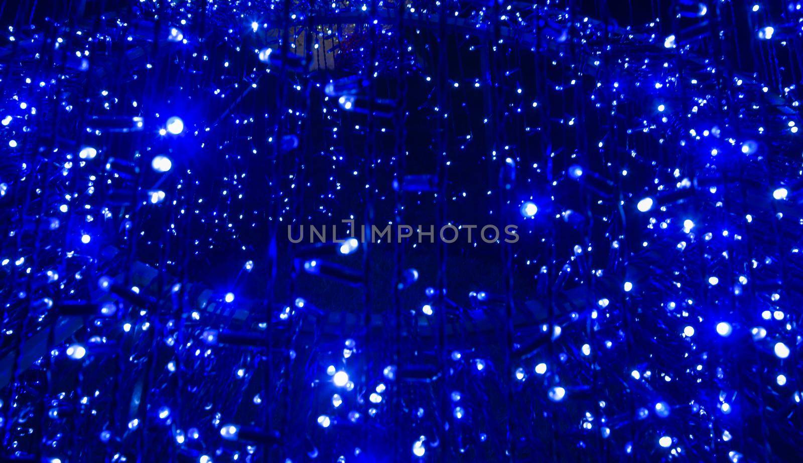 Beautiful abstract image of festive blue electric lights at night. Holiday decoration made of small electric lights.