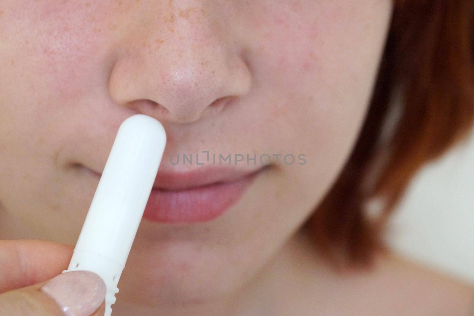 girl breathes with a small menthol inhaler close-up by Annado