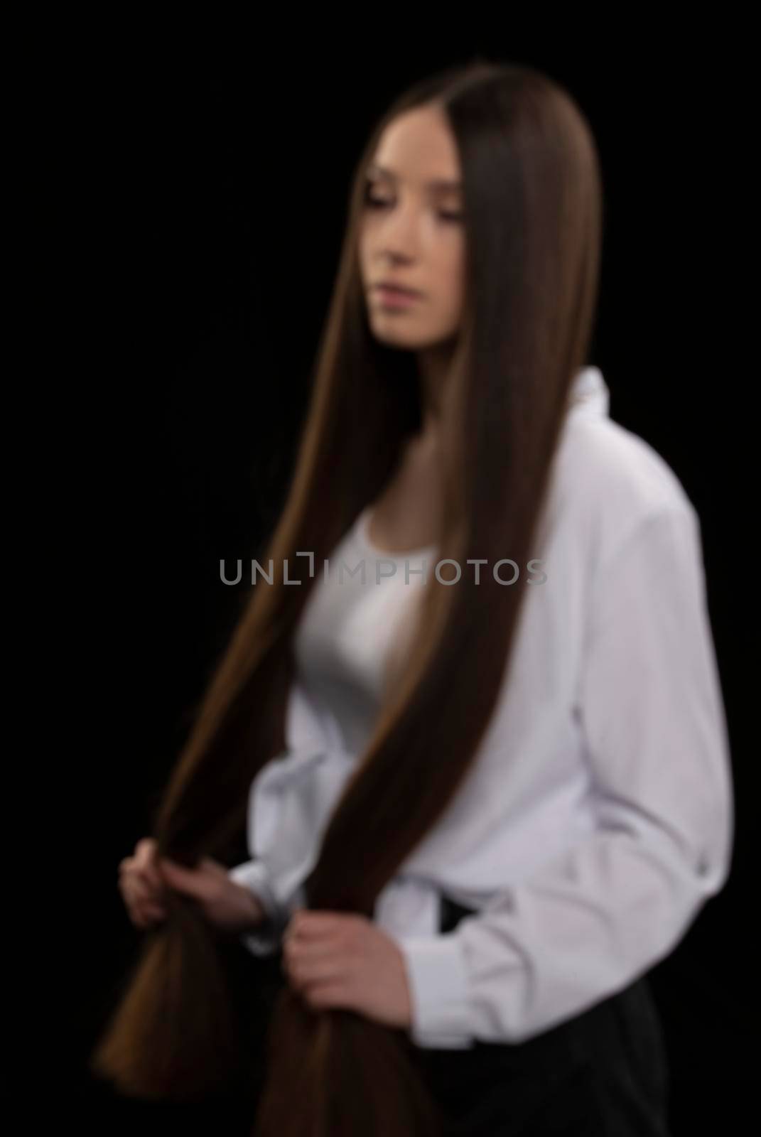 Blurred photo of a girl in rosofocus with long hair.