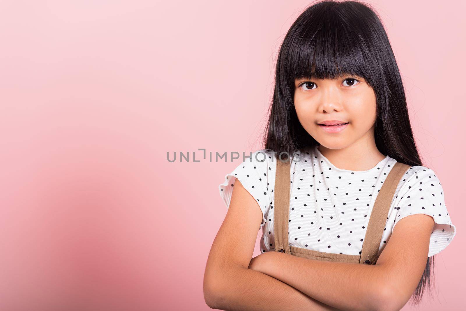 Asian little kid 10 years old smiling with arms crossed at studio shot isolated on pink background, Portrait of Happy confidence child girl lifestyle, Positive person