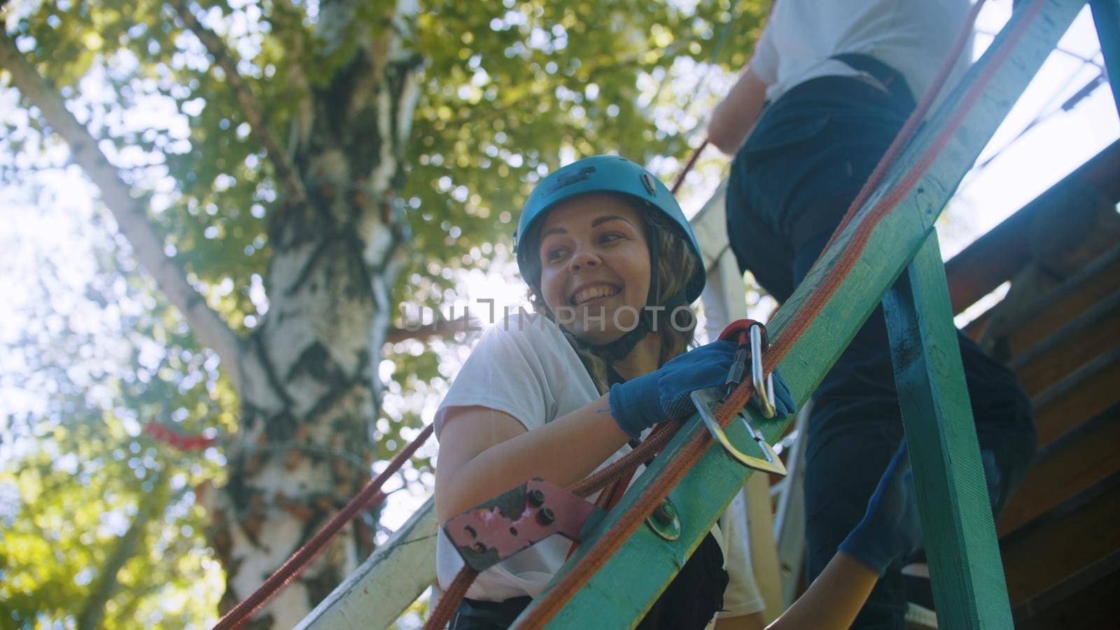 Rope adventure - couple walking upstairs to the attraction area - woman smiling. Mid shot