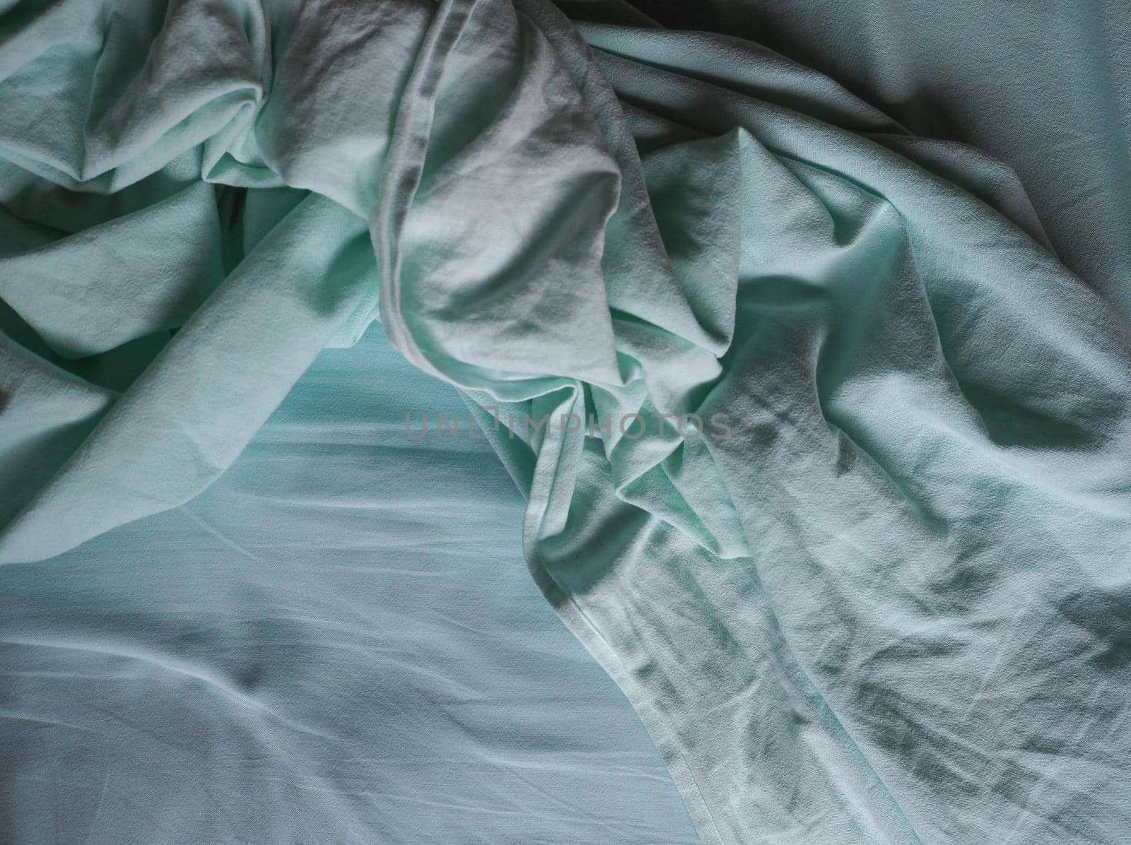 crumpled teal green fabric texture background by claudiodivizia