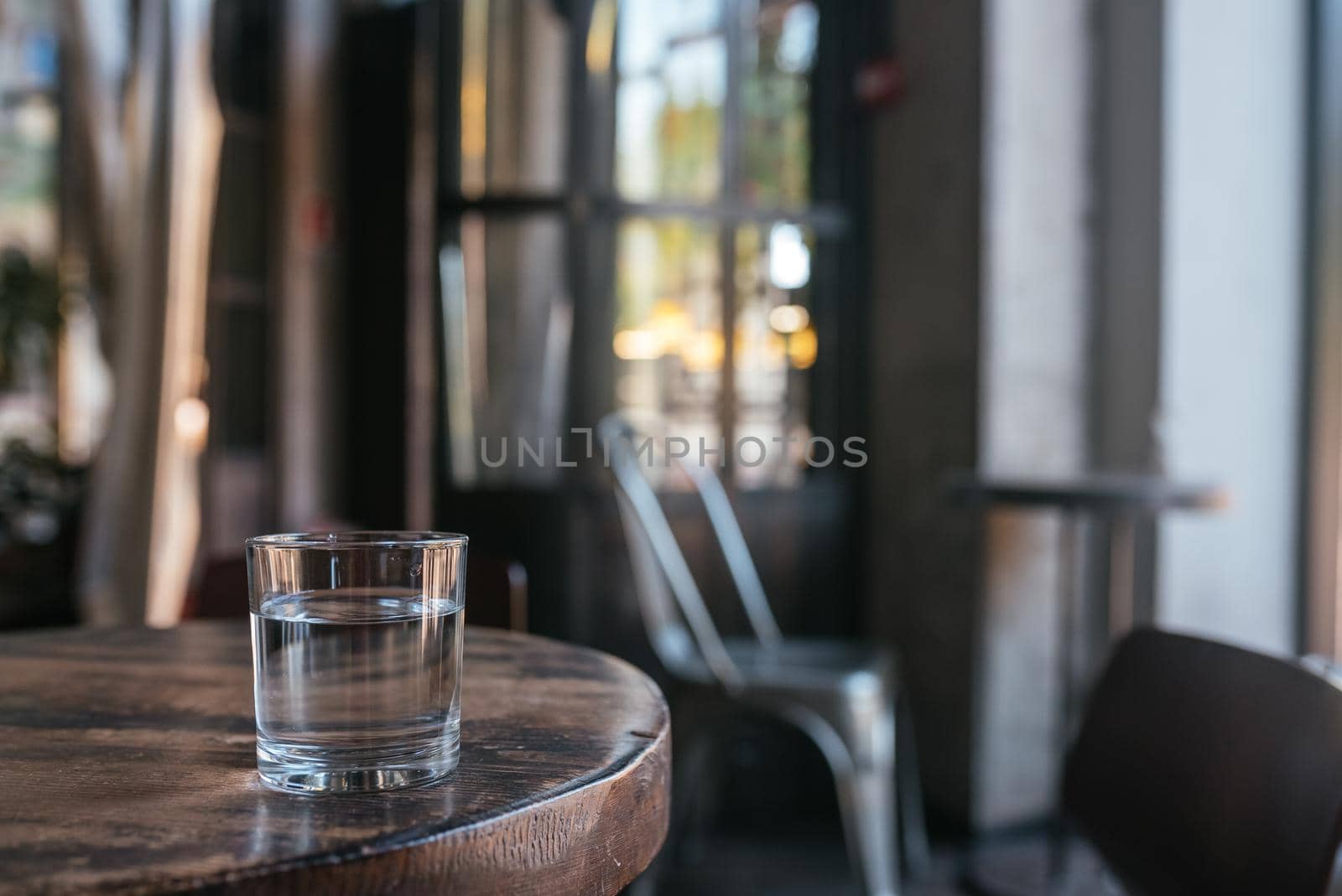 Glass of water on wooden table, blurred backgroun, close view