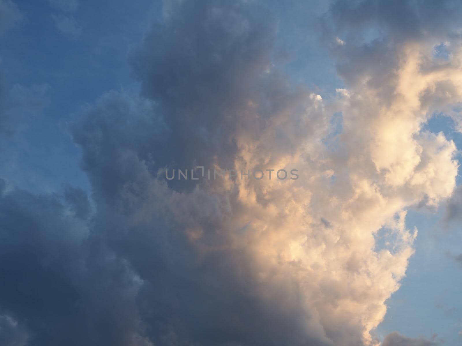 dramatic stormy blue sky with dark clouds at sunset useful as a background