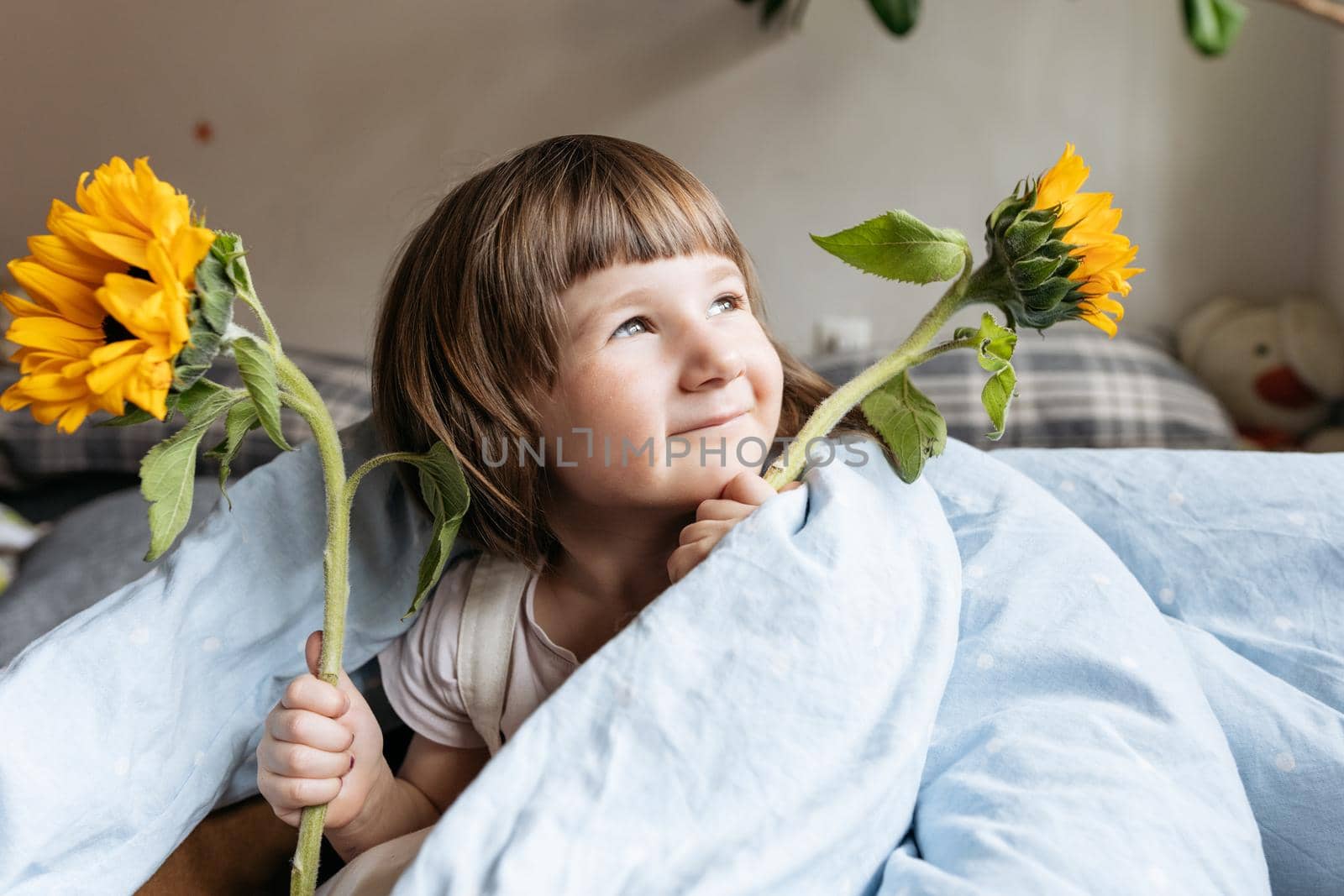 Portrait of a toddler girl holding sunflowers. High quality photo