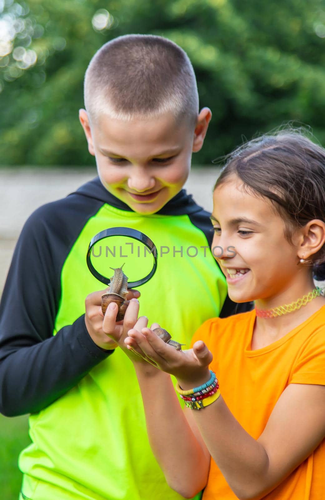 The child looks at the snail. Selective focus. by yanadjana