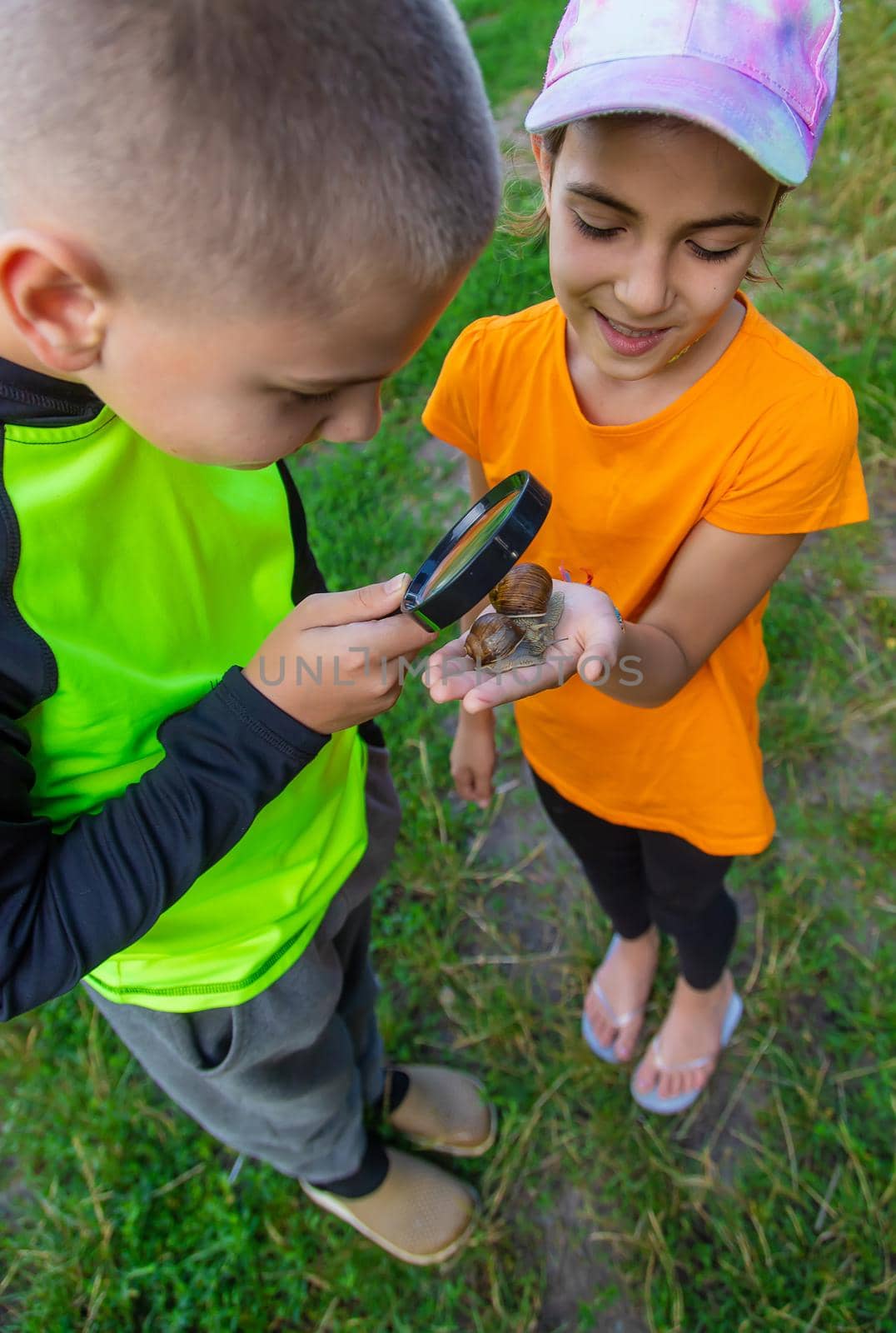 The child looks at the snail. Selective focus. by yanadjana