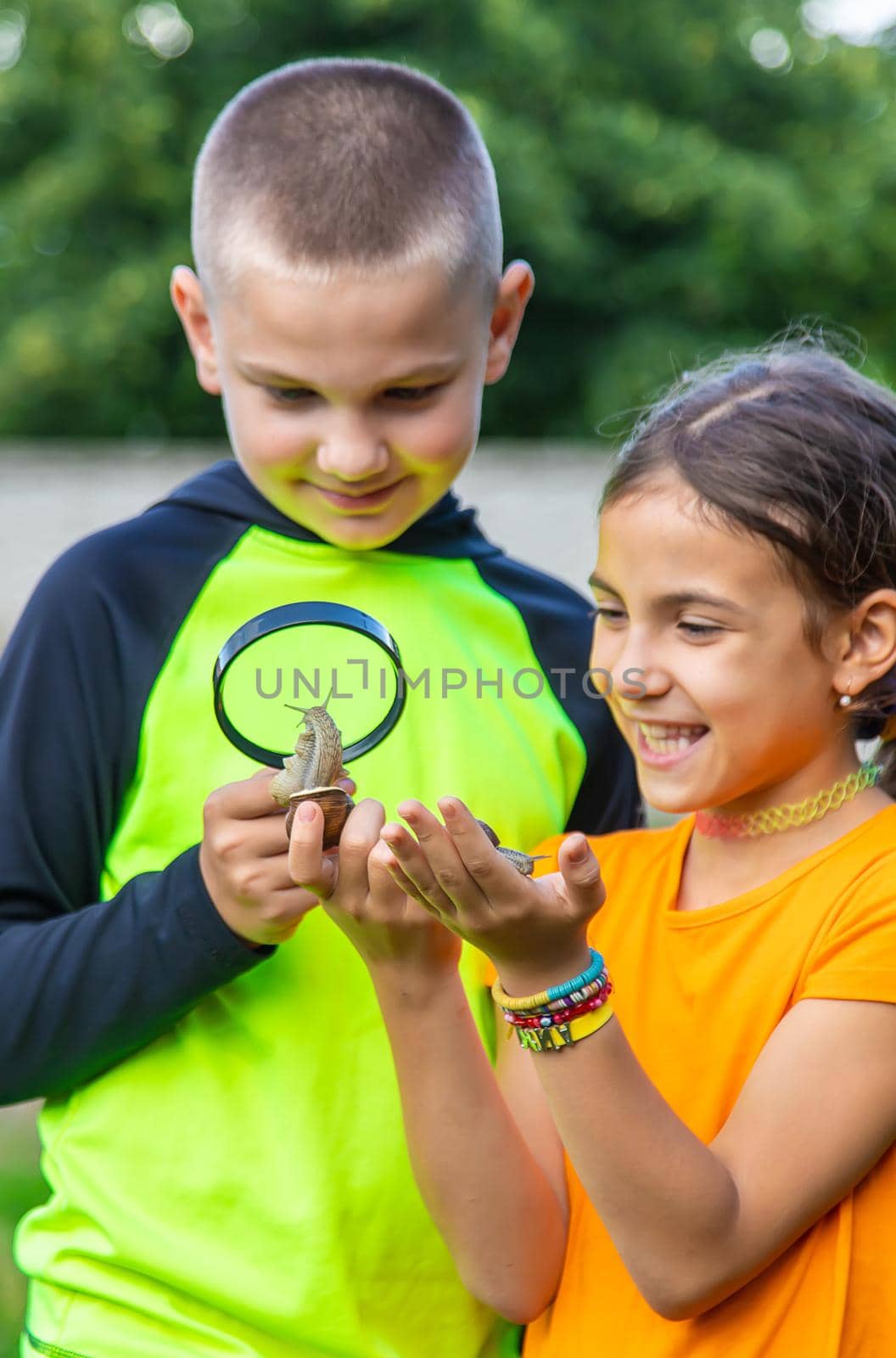 The child looks at the snail. Selective focus. Animal.