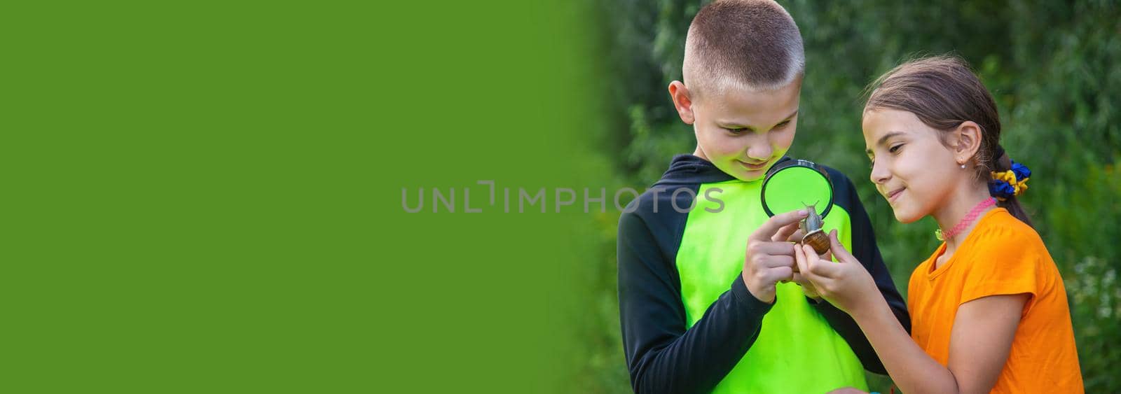 The child looks at the snail. Selective focus. by yanadjana