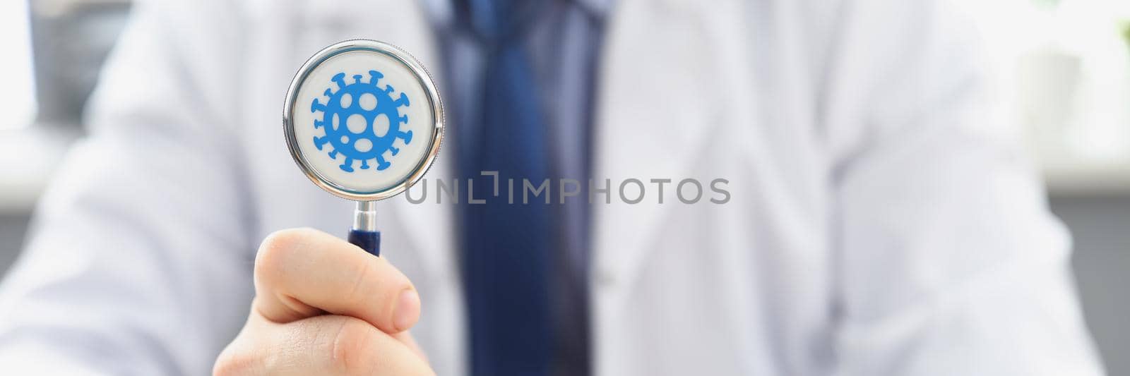 Close-up of doctor holding stethoscope infected with coronavirus, determining prognosis disease during pandemic. Handover of infection, medicine concept