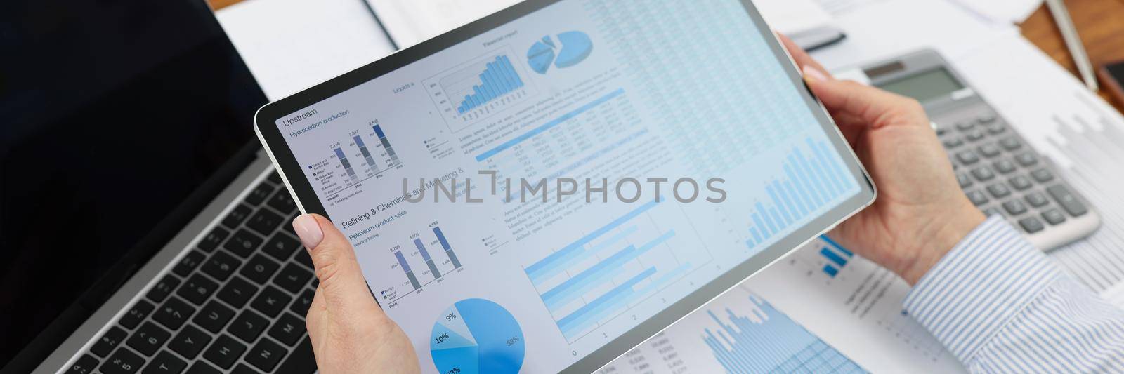 Worker going through digital papers on tablet in office by kuprevich