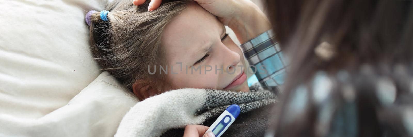 Portrait of sick girl stay in bed, mother measure temperature with electronic thermometer. Stay home on self isolation. Health, sickness, unwell concept