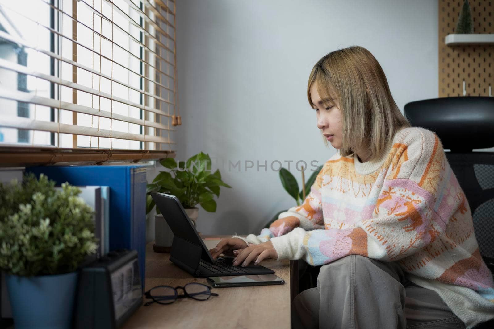 Young female freelancer working with computer table in comfortable home. by prathanchorruangsak