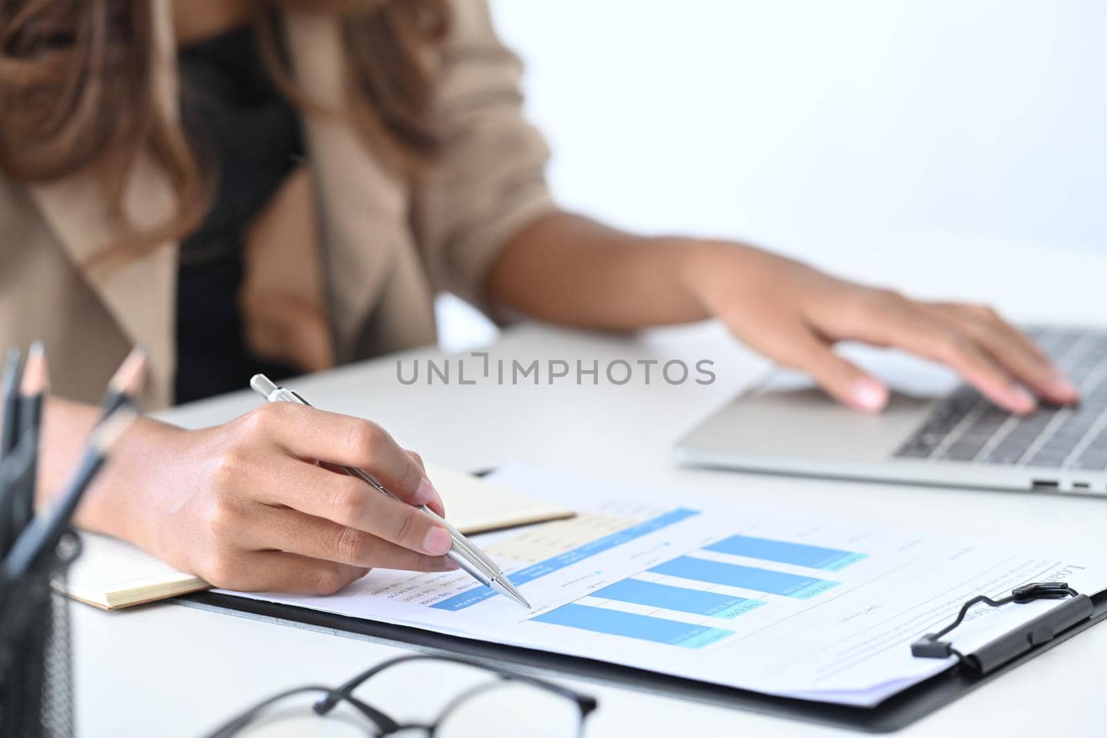 Close up businesswoman checking financial graph on office desk.