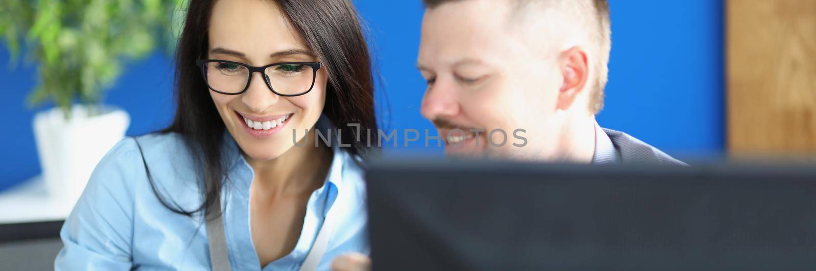 Portrait of woman and man workers in office discuss something and laugh. Friends share ideas on working place. Business, creative, plan, company concept