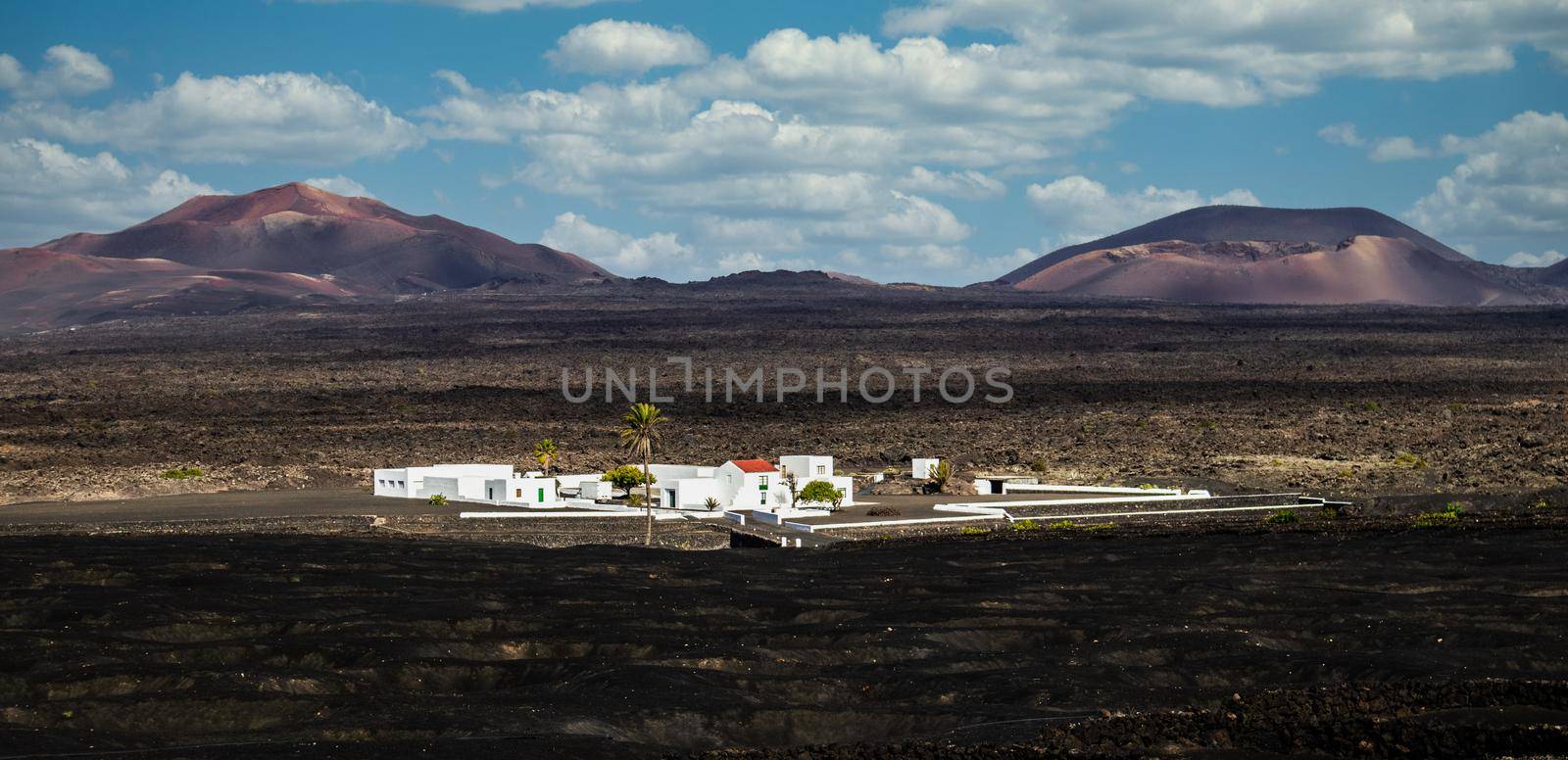 Amazing panoramic landscape of volcano craters in Timanfaya national park. Popular touristic village in La Gueria, Lanzarote island, Canary islans, Spain. Artistic picture by kasto