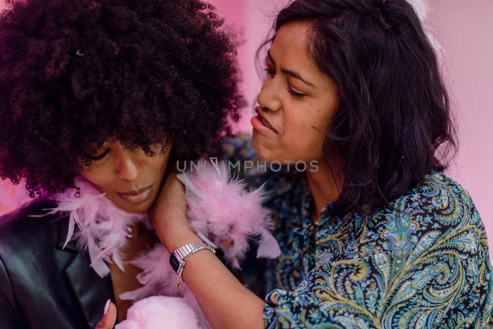multiracial female couple drinking and celebrating in a bar by verbano