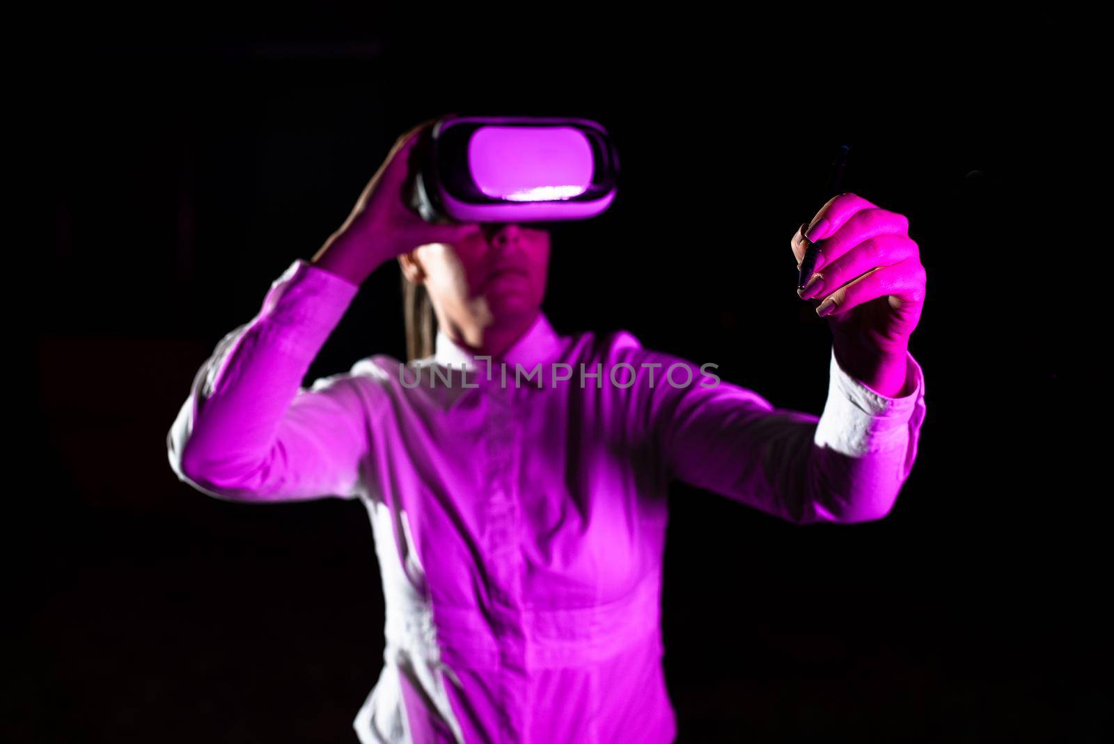 Female Manager Wearing Virtual Reality Headset Holding Pet While Taking Professional Training. Light Falling On Woman Using Gadget And Presenting Futuristic Technology. by nialowwa