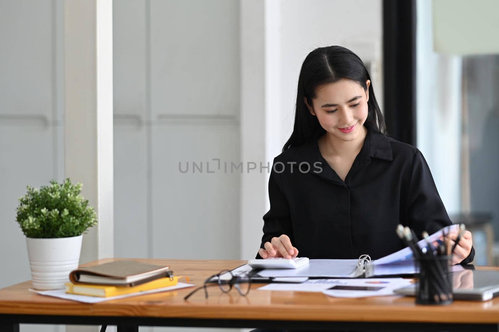 Beautiful businesswoman analyzing financial information in office. by prathanchorruangsak