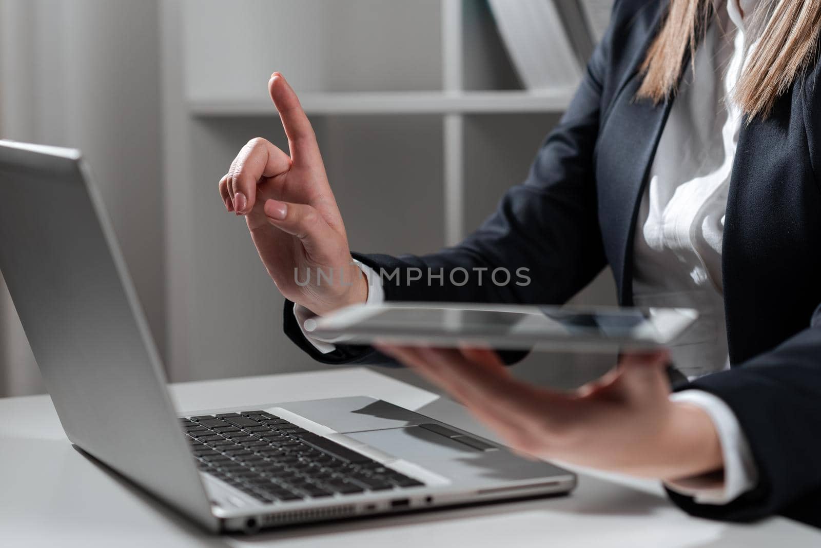 Woman Holding Tablet In One Hand And Pointing On News With One Finger.