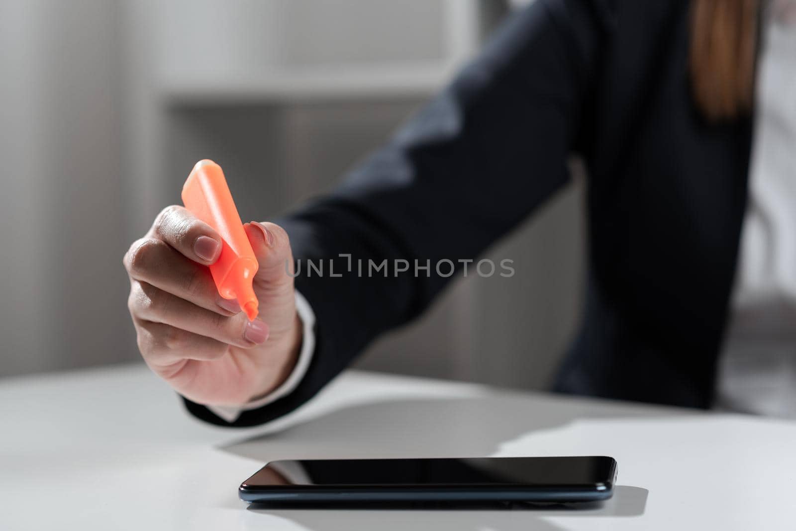 Businesswoman Pointing With Marker On Important Messages On Desk With Phone. Executive In Suit Presenting Crutial Informations With Coloring Pen On Table With Tablet. by nialowwa