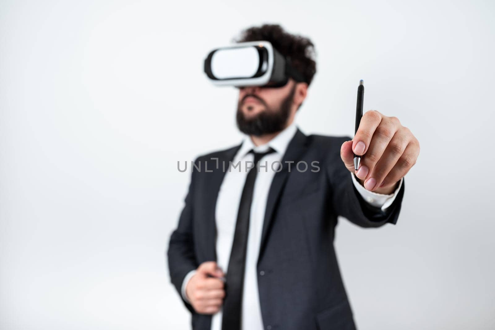 Man Wearing Vr Glasses And Pointing On Recent Updates With Pen. Businessman Having Virtual Reality Eyeglasses And Presenting New Idea. Executive Showing Late Data. by nialowwa