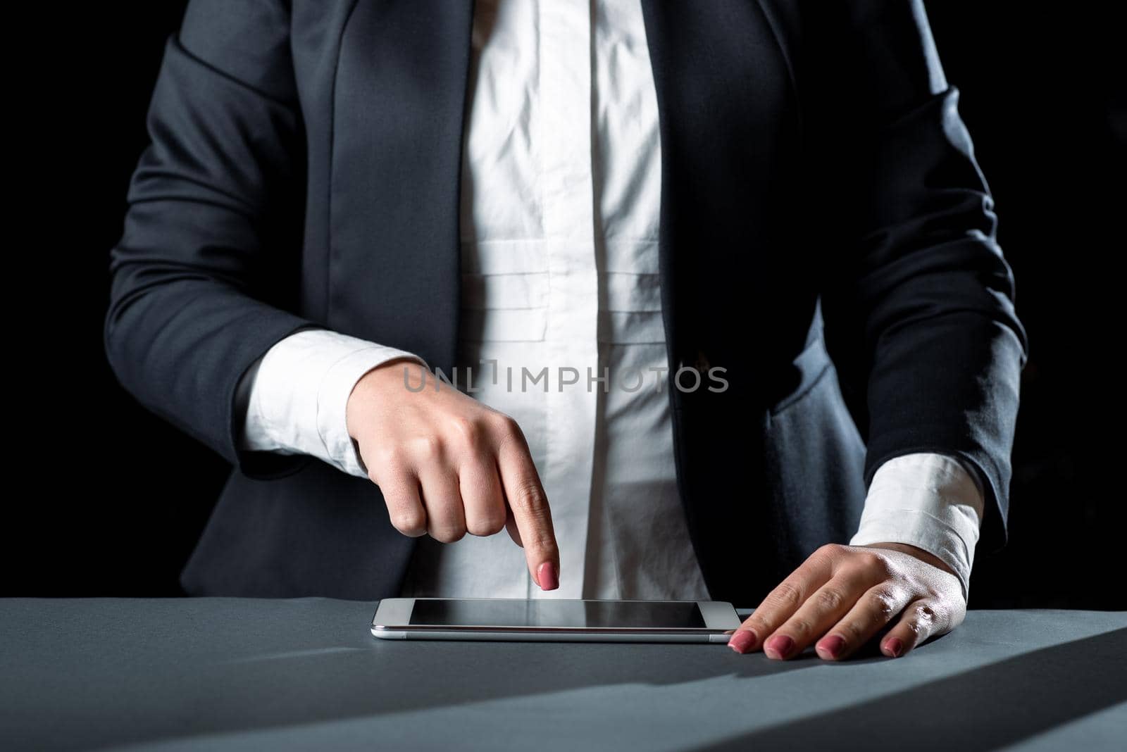 Businesswoman Having Tablet On Desk And Pointing On It With One Finger.