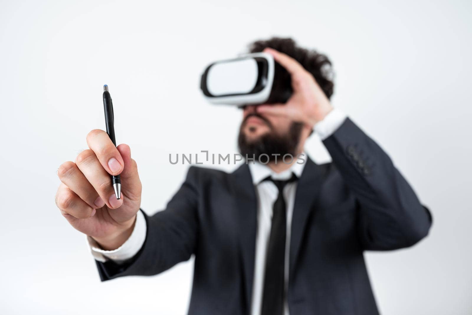 Man Wearing Vr Glasses And Pointing On Recent Updates With Pen. Businessman Having Virtual Reality Eyeglasses And Presenting New Idea. Executive Showing Late Data. by nialowwa