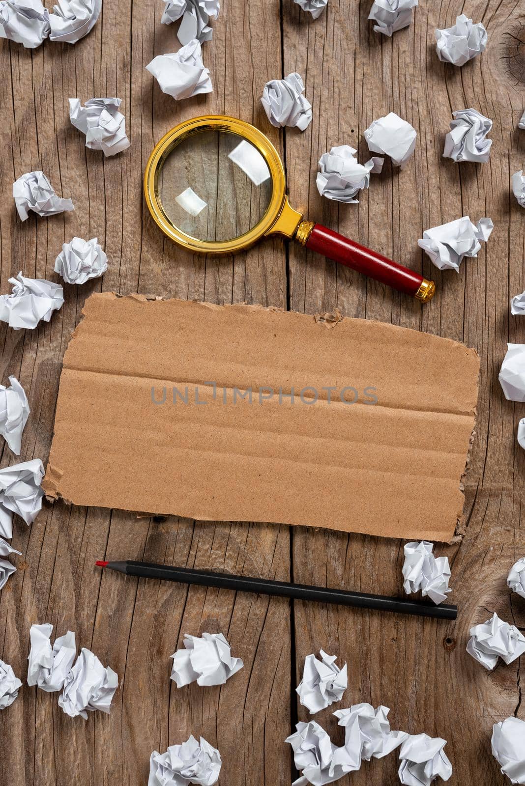 Cardboard With Important Information With Paper Wraps, Pencil And Magnifier Around. Paperboard With Crutial Message With Crumpled Notes All Over And Crayon. by nialowwa