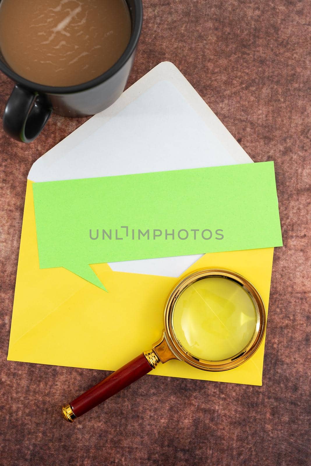 Blank Paper With Speech Bubble Shape, Envelope, Coffee Mug And Magnifying Glass Placed On Table. It Is Representing Important Marketing Strategies For Business Goals. by nialowwa