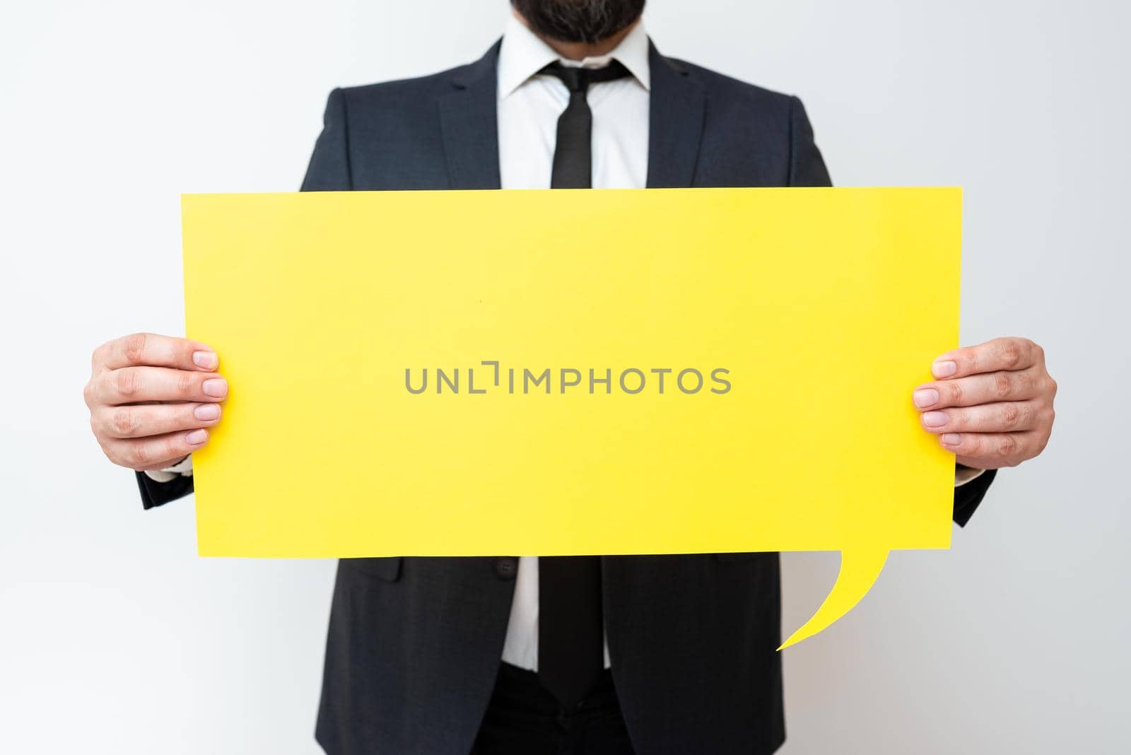 Businessman Holding Speech Bubble With Important Messages. Man In Suit Presenting Crutial Informations On Dialogue Balloon. Gentleman Showing Recent Updates On Paper. by nialowwa