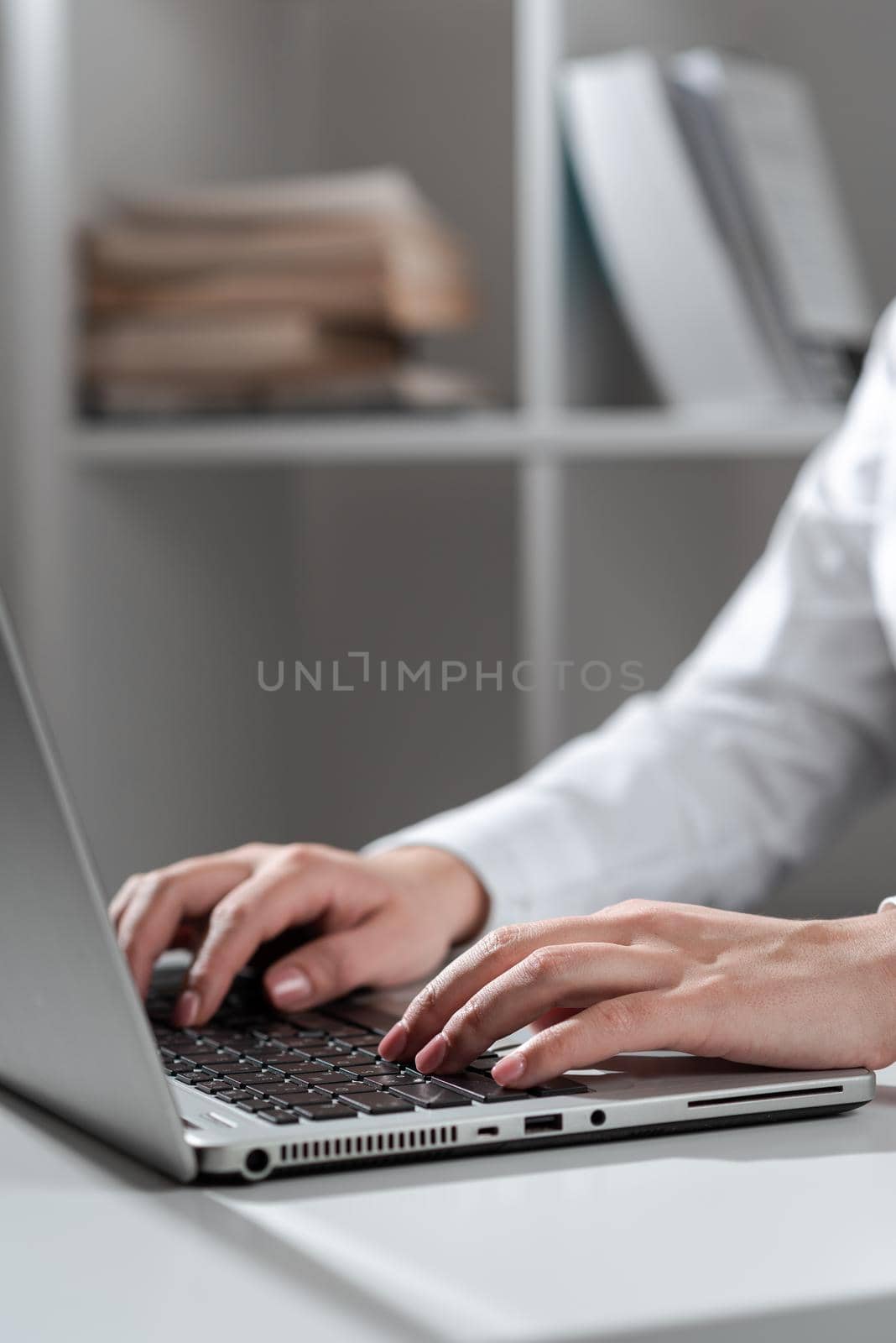 Businesswoman Typing Recent Updates On Lap Top Keyboard On Desk. Woman In Office Writing Important Message On Computer. Executive Inserting Crutial Data Into Pc. by nialowwa